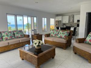 a living room with couches and a table with flowers at Villa Ferreira Punta Rucia near Ensenada beach in Punta Rucia