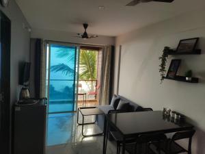 a living room with a table and chairs and a glass door at Dhayra's Seascape Apt @Dapoli in Dapoli