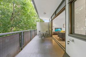 a room with a balcony with a table and chairs at Rooftop 2 Bed Apt With Terrace at Newtown in Sydney