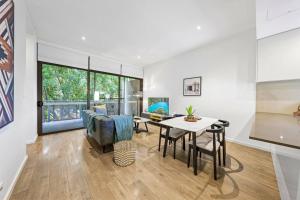 a living room with a table and a dining room at Rooftop 2 Bed Apt With Terrace at Newtown in Sydney