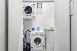 a laundry room with a washing machine and a washer at Rooftop 2 Bed Apt With Terrace at Newtown in Sydney