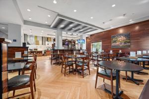 une salle à manger avec des tables et des chaises dans un restaurant dans l'établissement Four Points by Sheraton Jacksonville Baymeadows, à Jacksonville