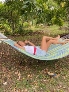 a woman laying in a hammock on the grass at Sugar Mountain Cottage in Saint Mary