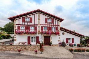 uma casa vermelha e branca com flores à frente em Chambres d'hôtes MANTTU em Urrugne