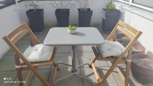 una mesa y 2 sillas con una mesa blanca en 2 Bedrooms House with garden and terrasse, en Saint-Cyr-lʼÉcole