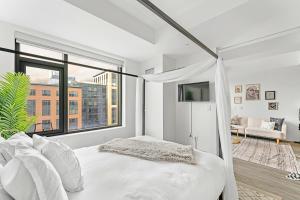 a white bedroom with a bed and a large window at Boston VIP Quarters by Orchard Group in Boston