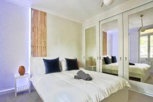 1 dormitorio con 1 cama blanca grande y espejo en Ideal 3 Bedroom House in Chippendale with 2 E-Bikes Included, en Sídney