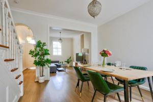 a dining room with a table and green chairs at Ideal 3 Bedroom House in Chippendale with 2 E-Bikes Included in Sydney