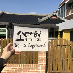 a person holding up a sign in front of a house at Sodamhang in Damyang in Damyang