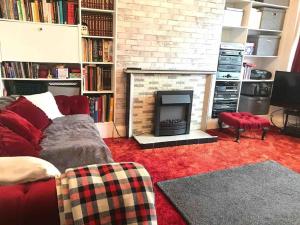 Una sala de estar con un sofá y una chimenea. en Newtons Lodge, en Nottingham