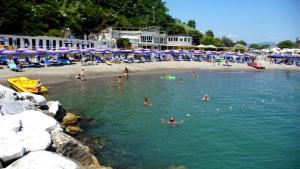 a group of people in the water at a beach at Casa Vacanza Sole terrazza in Ameglia
