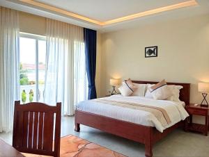 a bedroom with a large bed and a large window at Sokchea Kampot Hotel in Kampot