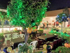 un grupo de mesas y sillas y un árbol con globos en HOTEL SHYAM PALACE INDIA AGRA, en Agra