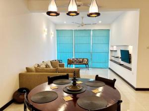uma sala de estar com uma mesa e um sofá em Mount Avenue IX by Ceylon Spaces em Watumulla