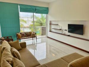 a living room with a couch and a flat screen tv at Mount Avenue IX by Ceylon Spaces in Watumulla