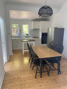 a kitchen with a table and chairs and a refrigerator at Freshly renovated gem - 1.5km from the city centre in Quarry Hill