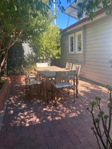 a wooden table and chairs on a patio at Freshly renovated gem - 1.5km from the city centre in Quarry Hill