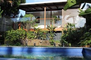 a house with a swimming pool in front of a building at CC's @ Byron Self Contained Studio in Byron Bay