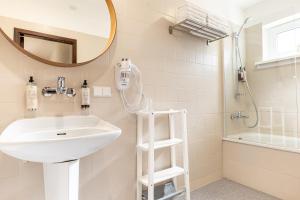 a bathroom with a sink and a shower and a mirror at Žilvinas Hotel in Palanga
