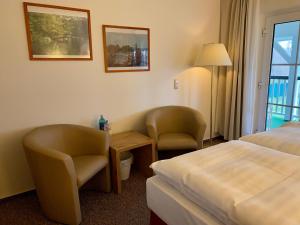 um quarto de hotel com uma cama, uma mesa e cadeiras em Landhaus am Schaalsee em Zarrentin