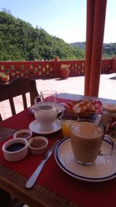 een tafel met borden en kopjes koffie bij Hostería La Porteña - La Serranita in La Bolsa