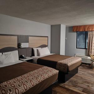 a hotel room with two beds and a window at Mountain Vista Inn & Suites - Parkway in Pigeon Forge