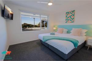 1 dormitorio con 2 camas y ventana en Botanic Racecourse, en Warrnambool