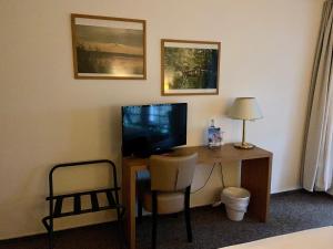 Zimmer mit einem Schreibtisch, einem TV und einem Stuhl in der Unterkunft Landhaus am Schaalsee in Zarrentin