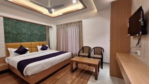 1 dormitorio con 1 cama y TV en una habitación en Hotel Lotus Blue By De Tulip en Bhopal