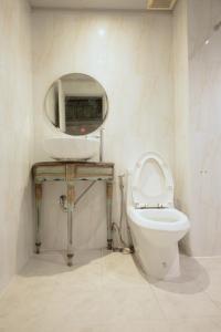 a bathroom with a toilet and a mirror at Mitr Inn Nimman 12 in Chiang Mai