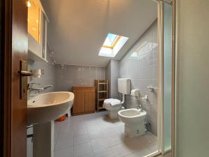 uma casa de banho com um lavatório, um WC e uma clarabóia em Casa Sonia Dongo - Larihome A52 em Dongo