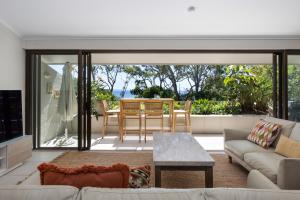 a living room with a couch and a table at Cove Point Apartment 5, Little Cove in Noosa Heads