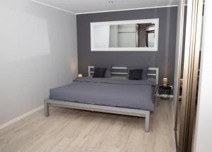 1 dormitorio con cama y espejo en la pared en Modern Beach Condo, Old Town 15min, Prime Location en Tallin