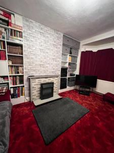 a living room with a fireplace and a red carpet at Newtons Lodge in Nottingham