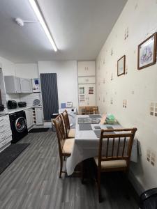 eine Küche mit einem Tisch und Stühlen im Zimmer in der Unterkunft Newtons Lodge in Nottingham