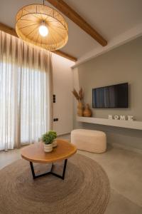 sala de estar con mesa de centro y TV en Palaia Luxury Suite, en Volos