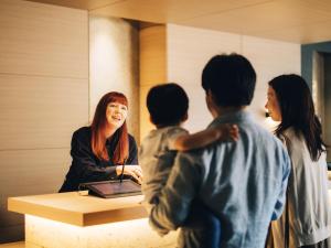 Eine Frau steht an einem Schreibtisch mit vier Kindern. in der Unterkunft MIMARU Tokyo STATION EAST in Tokio