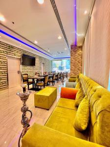 un soggiorno con divano giallo e tavolo di Zenith Smart Vacation Homes, Ajman ad Ajman