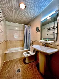 a bathroom with a sink and a toilet and a tub at Zenith Smart Vacation Homes, Ajman in Ajman 