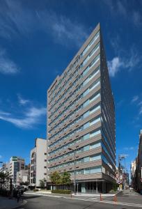 un edificio alto con ventanas en una calle de la ciudad en Fraser Residence Nankai Osaka, en Osaka
