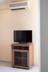 a flat screen tv sitting on top of a wooden entertainment center at Socrates studio in Laganas