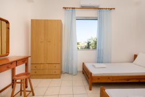 mały pokój z łóżkiem i oknem w obiekcie Alexis Apartments w mieście Stavros