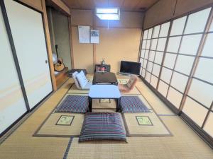 a room with mats on the floor and a table at 北アルプスの麓｜一軒家のシェアハウス内の和室宿／一匹のひつじ邸 in Ō-shinden