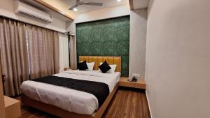 Un dormitorio con una cama grande y una pared verde en Hotel Lotus Blue By De Tulip en Bhopal