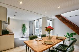 a dining room with a wooden table and green chairs at Spacious 3 Bedroom House Darlinghurst City Centre 2 E-Bikes Included in Sydney