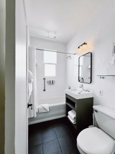 ein Badezimmer mit einem Waschbecken, einem WC und einem Spiegel in der Unterkunft FOUND Hotel Carlton, Nob Hill in San Francisco