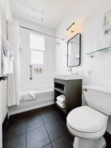 a white bathroom with a toilet and a sink at FOUND Hotel Carlton, Nob Hill in San Francisco