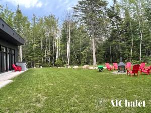 a group of chairs sitting in a yard at Forestia du Fief - Détente en forêt avec Spa in Petite-Rivière-Saint-François