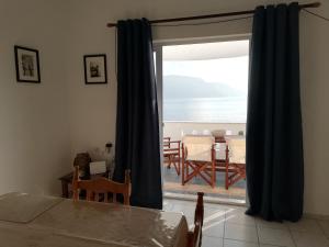 um quarto com uma porta de vidro deslizante e vista para o oceano em Panormitis Pizanias houses em Skaliá