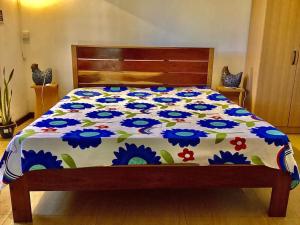 a bed with a flowered comforter on it at Original Villa in Trou d'Eau Douce